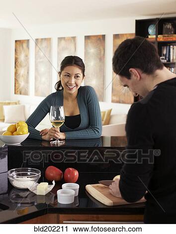 Couple cooking together in kitchen View Large Photo Image Stock Image - Couple cooking together in kitchen. Fotosearch