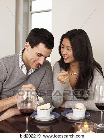 Stock Photo - Couple eating dessert together. Fotosearch