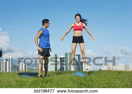 Couple exercising together in field View Large Photo Image Stock Photo - Couple exercising together in field. Fotosearch
