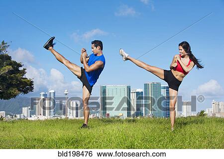 Stock Photograph - Couple exercising together in field. Fotosearch
