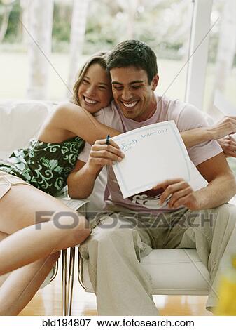Stock Photo - Couple hugging and holding certificate. Fotosearch