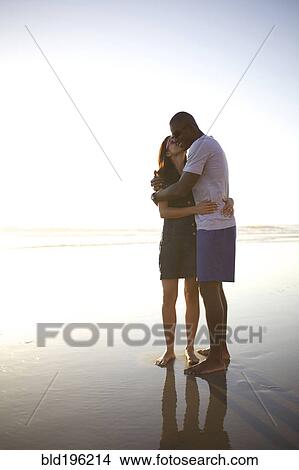 Couple hugging and kissing on beach View Large Photo Image Picture - Couple hugging and kissing on beach. Fotosearch