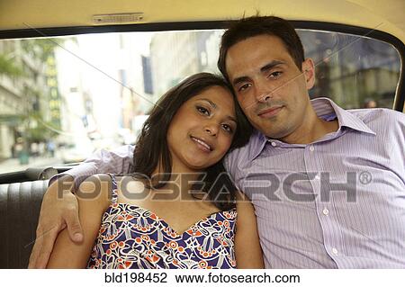 Stock Image - Couple hugging in back of taxi. Fotosearch