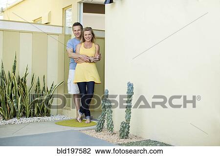 Stock Image - Couple hugging in doorway. Fotosearch