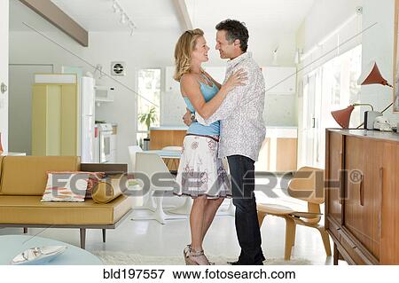 Couple hugging in living room View Large Photo Image Stock Photo - Couple hugging in living room. Fotosearch