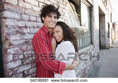 Stock Image - Couple hugging in urban area. Fotosearch