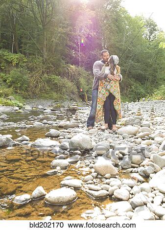 Couple hugging near stream View Large Photo Image Stock Image - Couple hugging near stream. Fotosearch