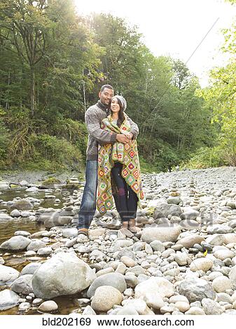 Stock Photo - Couple hugging near stream. Fotosearch
