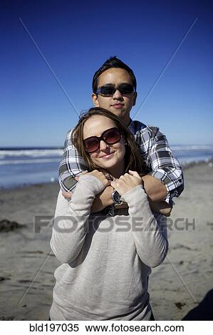 Stock Photography - Couple hugging on beach. Fotosearch