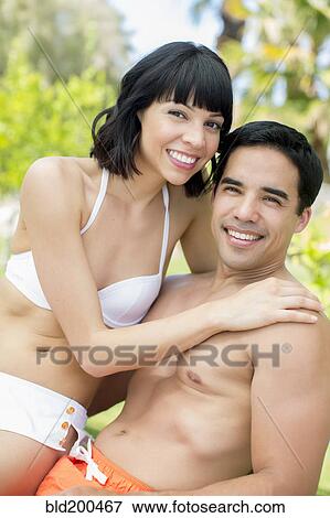 Stock Photo - Couple hugging outdoors in bathing suits. Fotosearch