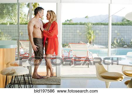Stock Photograph - Couple in bathing suits standing in doorway. Fotosearch