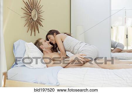 Couple kissing in bed View Large Photo Image Stock Image - Couple kissing in bed. Fotosearch