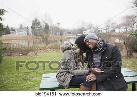 Couple laughing together in park View Large Photo Image Stock Image - Couple laughing together in park. Fotosearch