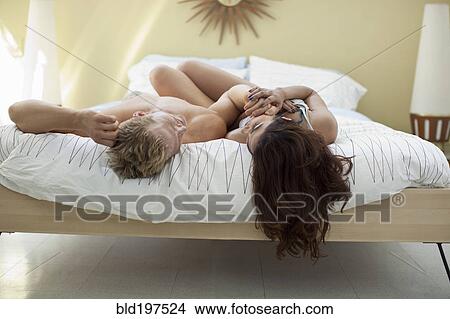 Couple laying in bed together View Large Photo Image Picture - Couple laying in bed together. Fotosearch
