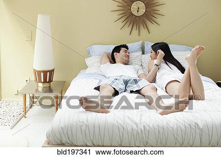 Couple laying in bed together View Large Photo Image Stock Image - Couple laying in bed together. Fotosearch