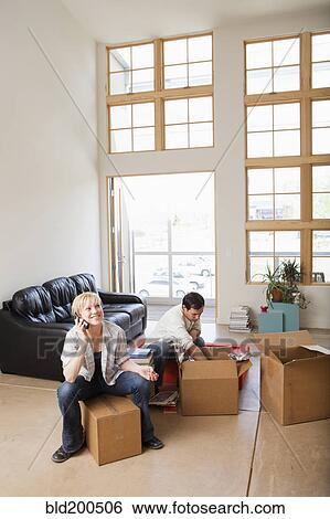 Couple moving into new house View Large Photo Image Stock Photograph - Couple moving into new house. Fotosearch