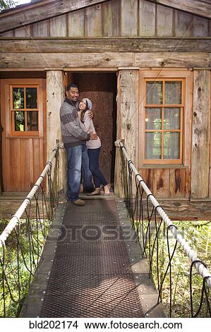 Picture - Couple on walkway of remote tree house. Fotosearch