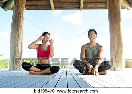 Stock Image - Couple practicing yoga together. Fotosearch