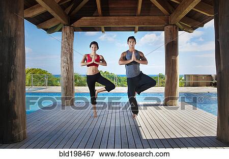 Stock Photo - Couple practicing yoga together. Fotosearch
