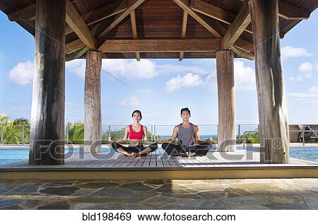 Couple practicing yoga together View Large Photo Image Stock Photo - Couple practicing yoga together. Fotosearch