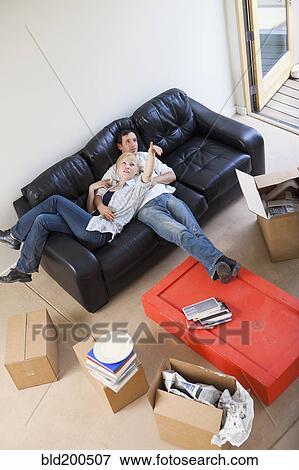 Stock Photo - Couple relaxation on sofa in livingroom. Fotosearch