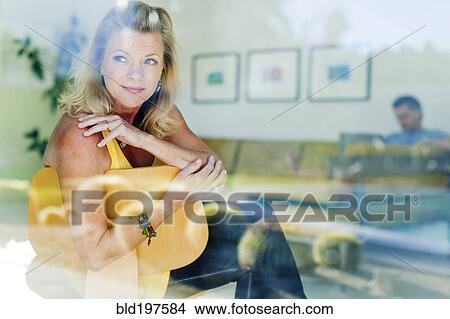 Couple relaxing together in living room View Large Photo Image Picture - Couple relaxing together in living room. Fotosearch