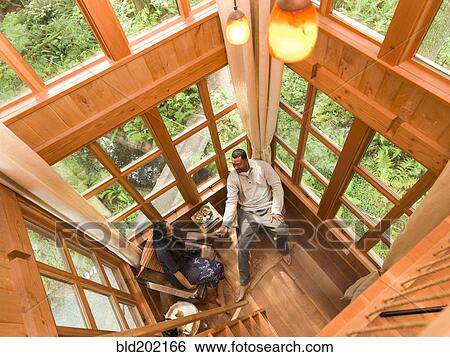 Stock Photograph - Couple relaxing together in small room. Fotosearch