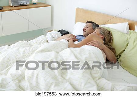 Stock Image - Couple sleeping in bed. Fotosearch