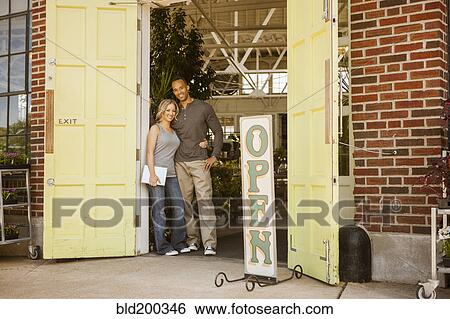 Stock Photograph - Couple standing in flower shop doorway. Fotosearch