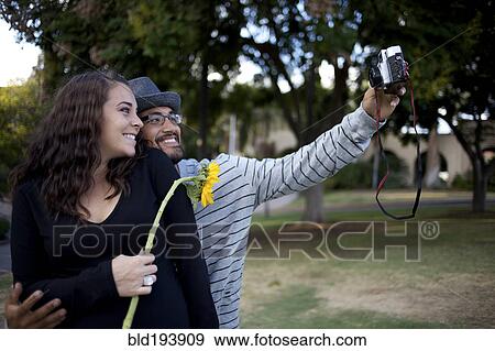 Stock Photo - Couple taking self-portrait. Fotosearch