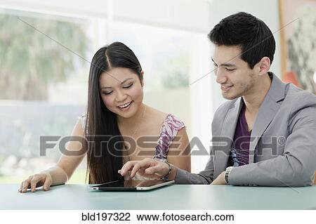Stock Image - Couple using digital tablet together. Fotosearch