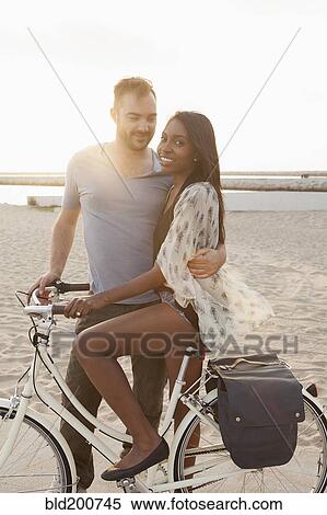 Stock Photography - Couple with bicycle on beach. Fotosearch