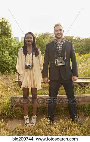 Couple with cameras holding hands View Large Photo Image Picture - Couple with cameras holding hands. Fotosearch