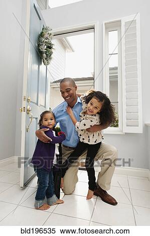 Stock Photography - Daughters greeting returning father. Fotosearch