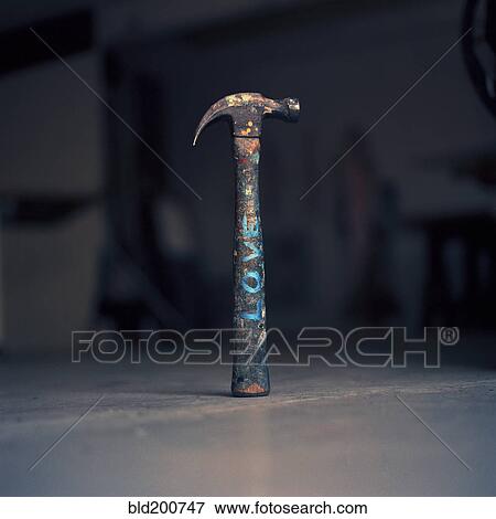 Stock Photo - Dirty hammer with the word 'love' written on it. Fotosearch