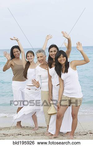 Diverse women standing on beach together waving View Large Photo Image Stock Photograph - Diverse women standing on beach together waving. Fotosearch