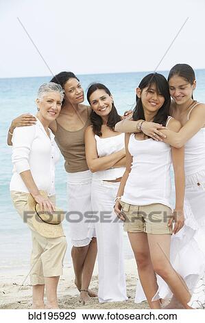 Stock Photo - Diverse women standing on beach together. Fotosearch