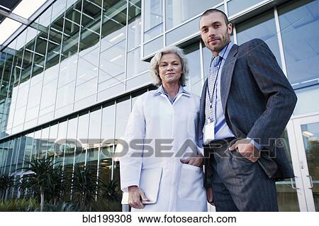 Doctor and businessman standing outdoors View Large Photo Image Stock Photo - Doctor and businessman standing outdoors. Fotosearch