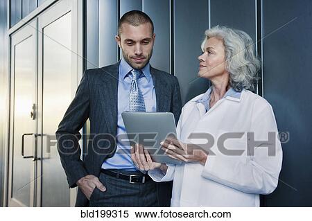 Doctor and businessman using digital tablet outdoors View Large Photo Image Stock Photography - Doctor and businessman using digital tablet outdoors. Fotosearch