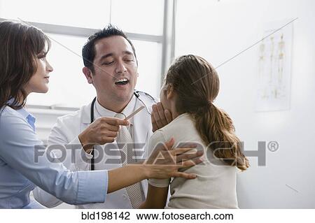 Stock Image - Doctor examining patient while mother watches. Fotosearch