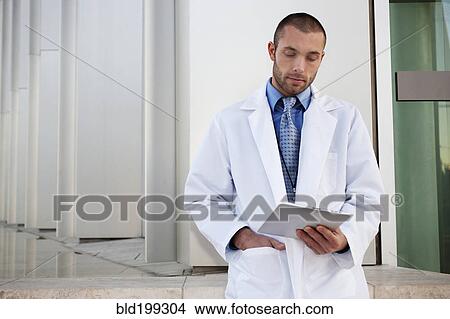 Picture - Doctor using digital tablet outdoors. Fotosearch