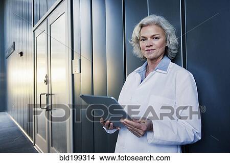 Picture - Doctor using digital tablet outdoors. Fotosearch