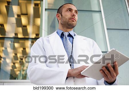 Doctor using digital tablet outdoors View Large Photo Image Stock Image - Doctor using digital tablet outdoors. Fotosearch