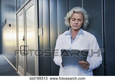 Stock Image - Doctor using digital tablet outdoors. Fotosearch