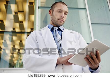 Stock Photo - Doctor using digital tablet outdoors. Fotosearch