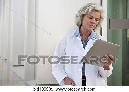 Doctor using digital tablet outdoors View Large Photo Image Stock Photography - Doctor using digital tablet outdoors. Fotosearch