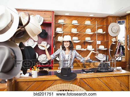 Stock Image - Ecuadorian woman working in hat store. Fotosearch