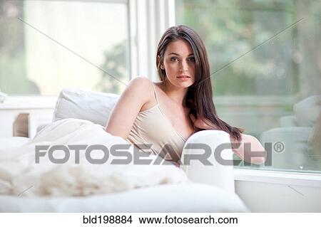 Picture - Elegant Caucasian woman sitting on sofa. Fotosearch