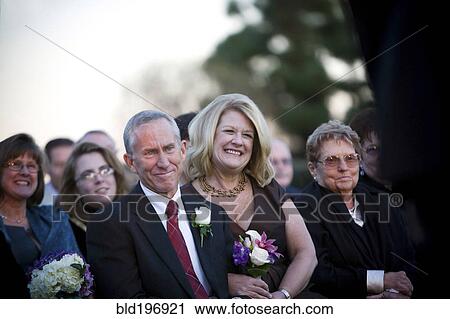 Stock Image - Family and guests watching wedding. Fotosearch