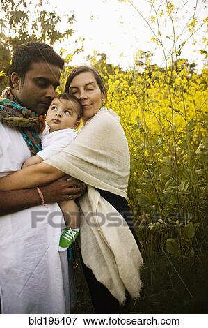 Stock Photo - Family hugging in field. Fotosearch